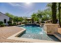 Beautiful swimming pool with stone waterfall feature and picturesque gazebo amidst mature trees at 6620 E Stallion Rd, Paradise Valley, AZ 85253