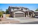 Inviting two-story home featuring a two-car garage, desert landscaping, and solar panels for energy efficiency at 1264 E Walnut Rd, Gilbert, AZ 85298