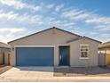 Charming single-story home featuring a blue garage door, desert landscaping, and a welcoming entryway at 3409 E Alexander Dr, San Tan Valley, AZ 85143