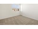 Spacious bedroom with neutral carpeting and a window with blinds at 36853 W La Paz St, Maricopa, AZ 85138