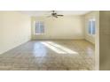 Spacious room with tile floors, large windows and a ceiling fan, offering ample natural light and a minimalist aesthetic at 1446 S Revere --, Mesa, AZ 85210