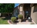 Welcoming front entrance with stone accents, arched windows, and landscaping at 1622 E Nighthawk Way, Phoenix, AZ 85048