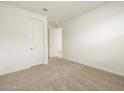 Spacious bedroom with neutral carpet and door at 36914 W La Paz St, Maricopa, AZ 85138
