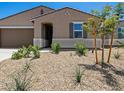 Landscaped front yard showcasing desert plants and trees complementing the house's architecture at 20357 N 225Th Dr, Surprise, AZ 85387