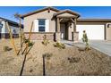 Single story house with a two-car garage, light colored exterior, and small front yard at 22526 W Tonopah Dr, Surprise, AZ 85387