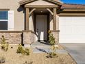 Front entrance with a covered porch, stone accents, and a double door at 22526 W Tonopah Dr, Surprise, AZ 85387
