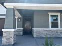 Inviting front porch with stone pillar accents at 20331 N 225Th Dr, Surprise, AZ 85387