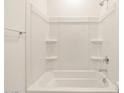 Clean white bathtub and shower combination with built-in shelving in bathroom at 4256 W Jeanette Ln, San Tan Valley, AZ 85144