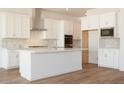 Bright kitchen boasts a large island, stainless steel appliances, and ample white cabinetry at 4780 W Flat Iron Ct, Queen Creek, AZ 85144