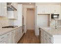 Modern kitchen design with stainless steel appliances, sleek white cabinets, and marble-look backsplash at 4780 W Flat Iron Ct, Queen Creek, AZ 85144