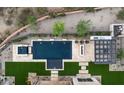 Aerial shot of the pool, spa, and outdoor kitchen with turf grass and desert landscaping at 8386 E Leaning Rock Rd, Scottsdale, AZ 85266