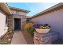 Inviting entryway with stone accents and colorful flower planter at 19403 N Ponderosa Ct, Surprise, AZ 85387