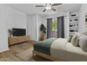 Bright bedroom with a ceiling fan, a sliding glass door, and built-in shelving at 3845 E Greenway Rd # 131, Phoenix, AZ 85032