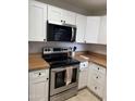 Modern kitchen boasts stainless steel oven, microwave, white cabinets, and wood-look countertops at 3845 E Greenway Rd # 131, Phoenix, AZ 85032