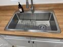 Close-up of the stainless steel kitchen sink with wood-look countertops and stylish faucet at 3845 E Greenway Rd # 131, Phoenix, AZ 85032