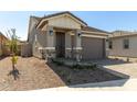 Inviting single-story home featuring stone accents, a tidy front yard, and a covered entryway at 5678 N 205Th Ln, Buckeye, AZ 85396
