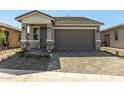 Well-maintained single-story home with a two-car garage, neat landscaping, and a cozy entrance at 5678 N 205Th Ln, Buckeye, AZ 85396