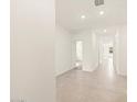 Long tiled hallway with doors leading to bedrooms, bathrooms, and other living spaces at 16025 W Cottontail Ln, Surprise, AZ 85387