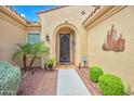 Inviting home entrance with landscaped walkway, decorative door, and unique wall art at 13668 W Figueroa Dr, Sun City West, AZ 85375