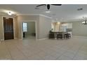 Open-concept living room with tile floors, ceiling fan, and view of the kitchen and another room at 13668 W Figueroa Dr, Sun City West, AZ 85375
