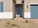 Inviting front entry showcasing a blue door and a well-maintained brick pathway leading to the entrance at 17654 W Pierson St, Goodyear, AZ 85395