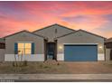 Beautiful home featuring a gravel front yard, blue garage door, and stunning twilight sky, perfect for curb appeal at 17654 W Pierson St, Goodyear, AZ 85395