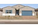 Attractive single-Gathering house with a two-car garage, blue accents, and low-maintenance landscaping at 17654 W Pierson St, Goodyear, AZ 85395