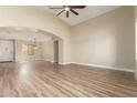 Bright and airy living room with hardwood flooring, an arched doorway, and a soaring ceiling with fan at 2156 E Aloe Pl, Chandler, AZ 85286