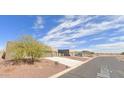 Street view of a home showing the desert landscape with a large driveway and multiple garage spaces at 10298 W Morgan Ct, Casa Grande, AZ 85194