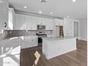 Modern white kitchen with island and stainless steel appliances at 40549 W Wade Dr, Maricopa, AZ 85138