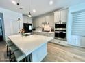 Modern kitchen featuring an island with seating, stainless steel appliances, and white cabinetry at 6437 N 17 St, Phoenix, AZ 85016