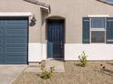 Modern front door with black shutters and a walkway at 16006 W Cottontail Ln, Surprise, AZ 85387