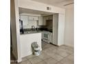 Bright kitchen features white cabinets and appliances, with a breakfast bar at 18202 N Cave Creek Rd # 107, Phoenix, AZ 85032