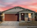 Charming house with a brown garage door and stone accents at 16014 W Cottontail Ln, Surprise, AZ 85387