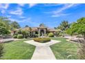 Charming home featuring a lush front yard with manicured lawn, mature trees, and a decorative fountain at 4222 E Brown Rd # 31, Mesa, AZ 85205