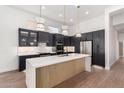 Modern kitchen with dark cabinetry, marble countertops, and a large island at 11568 E Whispering Wind Dr, Scottsdale, AZ 85255