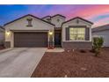 A welcoming one-story home with a dark garage door and autumn decor at 18785 W Wilson St, Buckeye, AZ 85326