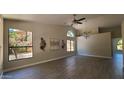 Spacious living area with vaulted ceilings, wood-look tile floors, and large windows at 5452 S Pyrite Cir, Gold Canyon, AZ 85118