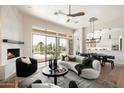 Bright living room with fireplace, stylish furnishings, and sliding doors to a backyard oasis with pool at 34599 N 99Th Way, Scottsdale, AZ 85262