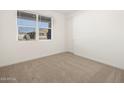 Simple bedroom with carpeted floor and a window with blinds at 36933 W La Paz St, Maricopa, AZ 85138