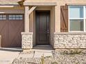 A charming front entrance featuring a decorative wood door and stone facade at 36944 W Prado St, Maricopa, AZ 85138