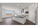 Bright kitchen with white cabinets, stainless steel appliances, and sleek black countertops at 17134 W Hackamore Dr, Surprise, AZ 85387