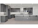 Modern eat-in kitchen with large island, sleek gray cabinets, and stainless steel appliances at 25137 N 171St Ave, Surprise, AZ 85387