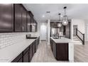 A modern kitchen features dark cabinetry, a center island with white countertops, and stainless steel appliances at 756 E Zion Dr # 103, Gilbert, AZ 85297