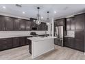 A modern kitchen features dark cabinetry, a center island with white countertops, and stainless steel appliances at 756 E Zion Dr # 103, Gilbert, AZ 85297