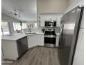 Bright kitchen with white cabinets, stainless steel appliances, and subway tile backsplash at 15075 W Amelia Dr, Goodyear, AZ 85395