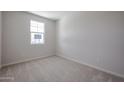 Cozy bedroom with neutral carpet, a window, and ample natural light at 40010 W Bravo Dr, Maricopa, AZ 85138