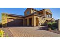 Two-story home with a brown garage door and brick driveway at 7325 E Conquistadores Dr, Scottsdale, AZ 85255