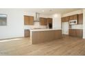 Open concept kitchen with wooden cabinets, stainless appliances, an island, and tile floors at 829 W Golden Ore Pass, Apache Junction, AZ 85120
