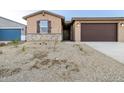 Charming single-story home with a brown two-car garage and a low maintenance gravel front yard at 22455 W Pontiac Dr, Surprise, AZ 85387